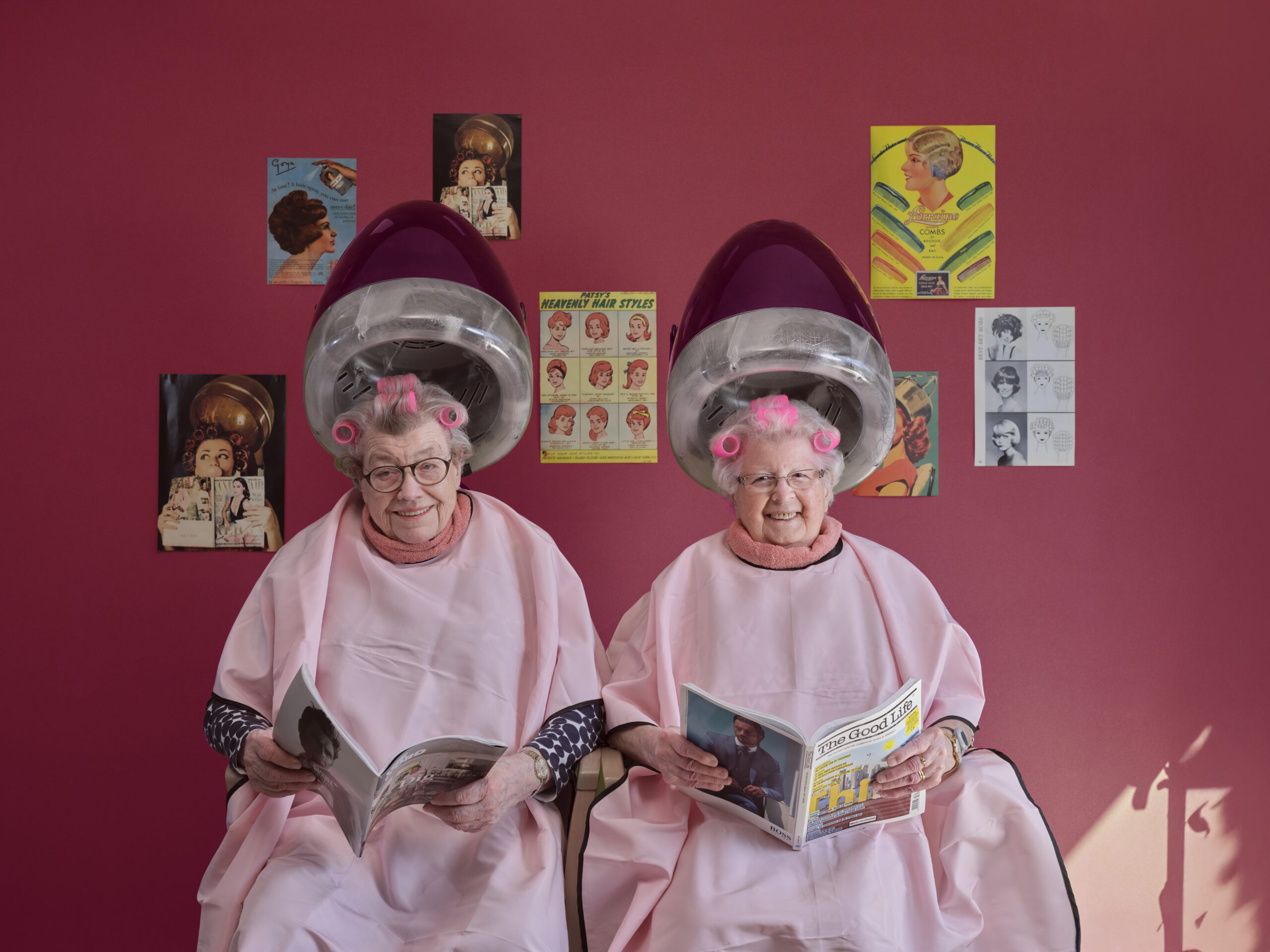 Two ladies sitting under hair dryers